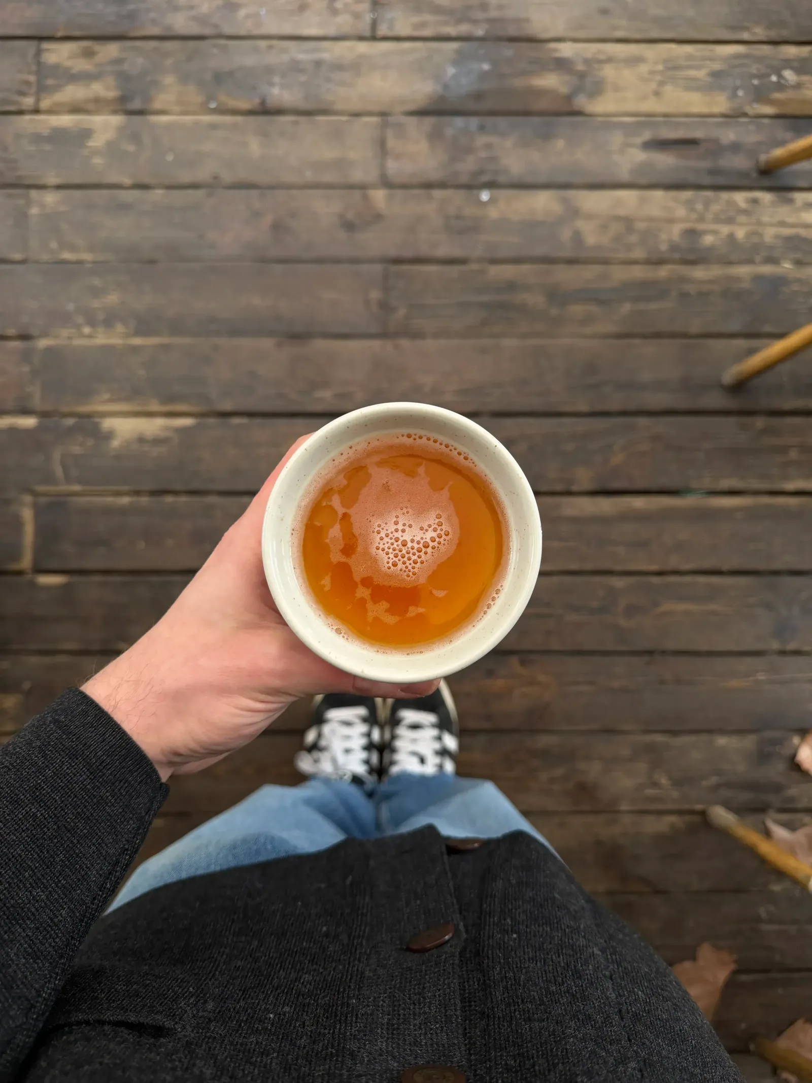 Bolée de cidre tenue au-dessus du parquet de la crêperie